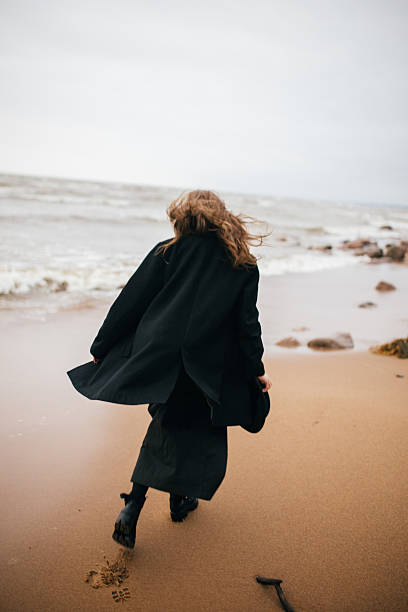 istock Girl walking on the sea shore 502075340