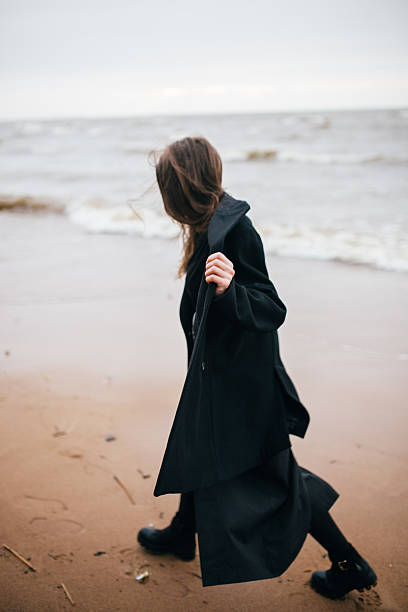 istock Girl walking on the sea shore 502075356