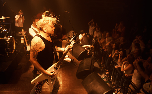 A band playing their hearts out at a festival show. This concert was created for the sole purpose of this photo shoot, featuring 300 models and 3 live bands. All people in this shoot are model released.