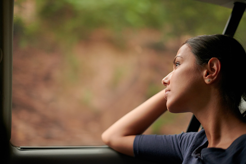 A beautiful woman looking out of a car window