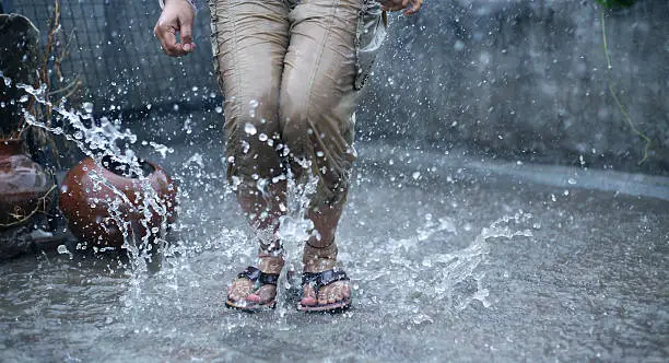 Photo of Woman's Legs jumping in the Rain