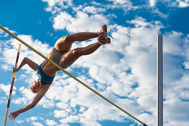 istock Young Women Jumping Over the Lath Against Cloudy Sky 502089069