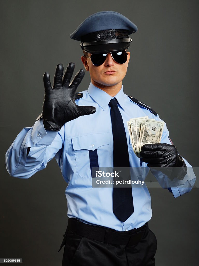 Policeman shows stop Policeman in uniform shows you stop with leather glove and holds money Adult Stock Photo