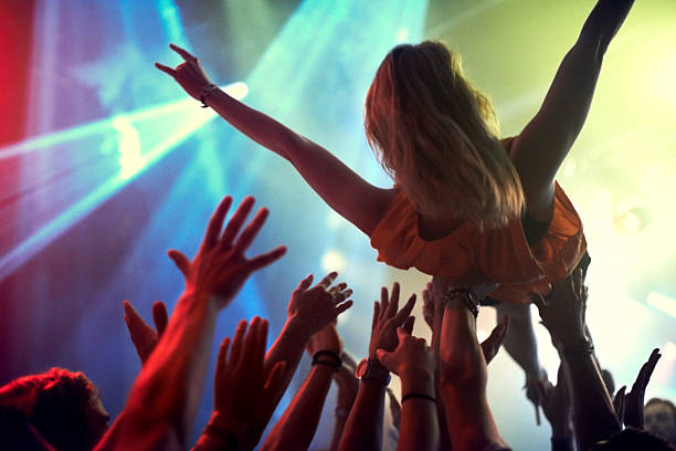 The only way to feel at one with an audience A young girl crowd surfing as a band plays one of her favourite songshttp://195.154.178.81/DATA/i_collage/pi/shoots/782538.jpg mosh pit stock pictures, royalty-free photos & images