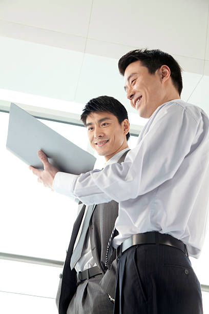 deux hommes d'affaires travaillant ensemble - book holding necktie businessman photos et images de collection