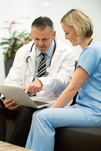 istock male and female doctor looking data at notebook computer 502091215