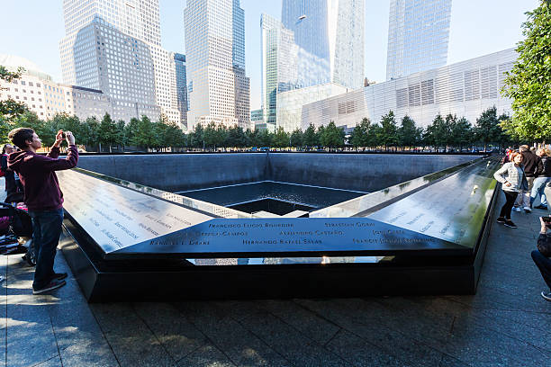 September 11 Memorial in Manhattan, NYC New York City, US - October 06, 2015: National September 11 Memorial in Lower Manhattan, with unidentified people. It commemorates the September 11, 2001, attacks, which killed 2,977 victims, and the World Trade Center bombing of 1993, which killed six.  bomb photos stock pictures, royalty-free photos & images