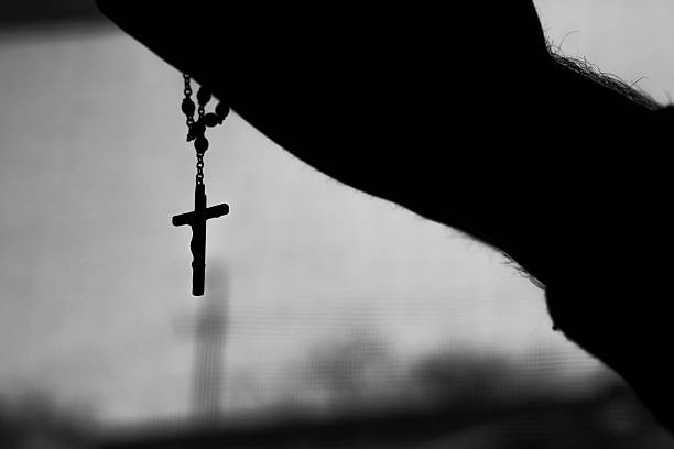 istock silhouette of hand holding up cross concept 502102368