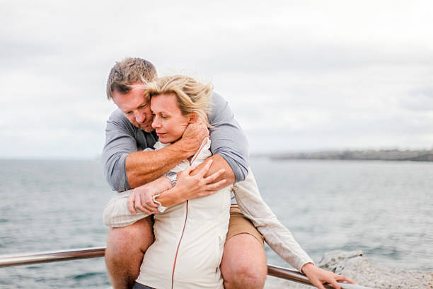 istock couple hugging on a railing near an ocean 502102460