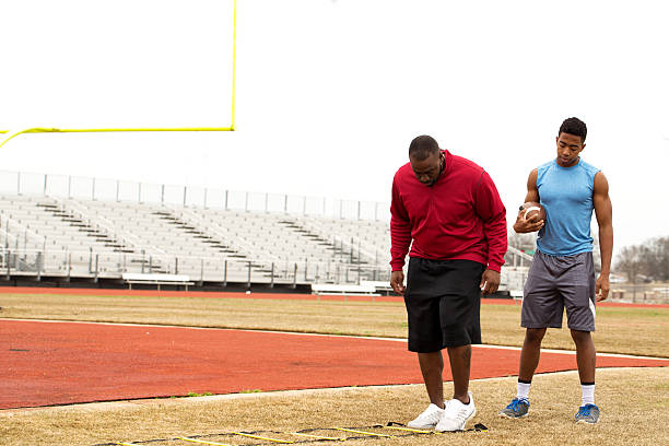 istock Coach training a high school athlete for football. 502103368