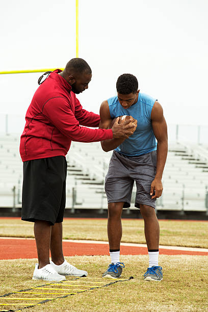 istock Coach training a high school athlete for football. 502103580
