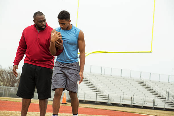 istock Coach training a high school athlete for football. 502103622
