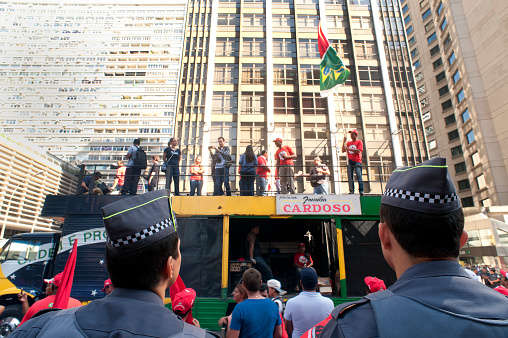 São Paulo, Brazil, July, 03, 2014: Military police watch protestersof the landless workers ' movement (FNL) who carried out a march of 20 days in the State to the capital to deliver a letter of demands at the Office of the Presidency of the Republic