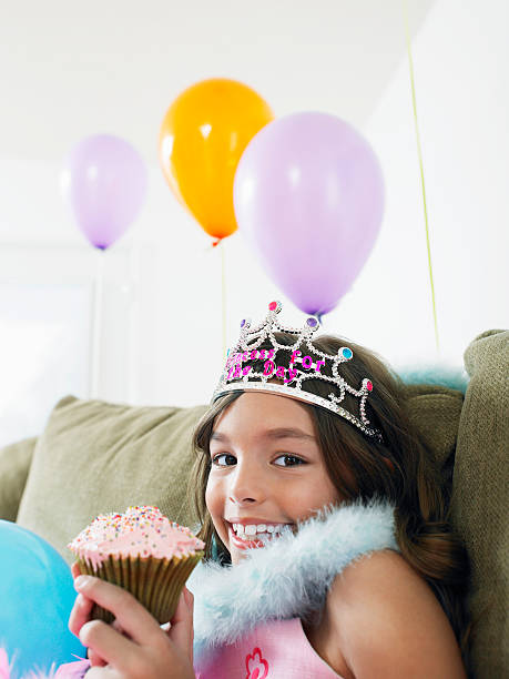 istock Happy Girl On sofa With Balloons And Cupcake 502117685