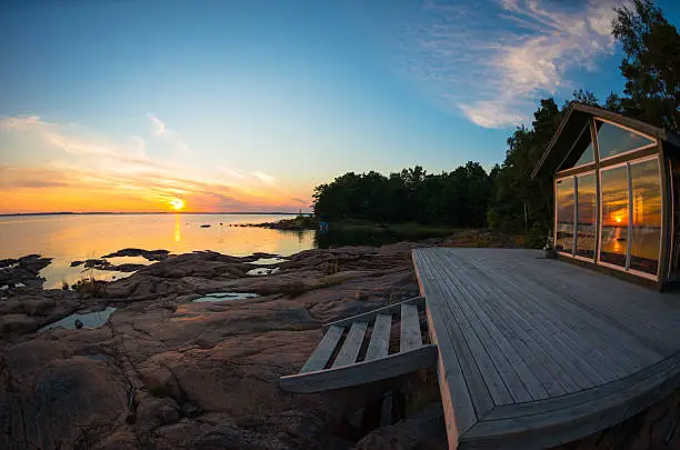 Summer cottage patio by the water at sunset