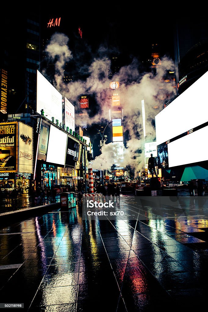 Rainy Times Square at midnight. Smoke stacks lets out steam in Times Square. Rainy night. Neon Lights. Times Square - Manhattan Stock Photo