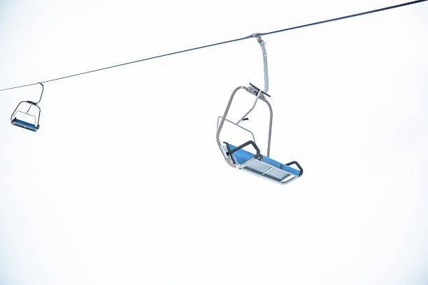 istock Ski lift chairs on bright winter day 502118869