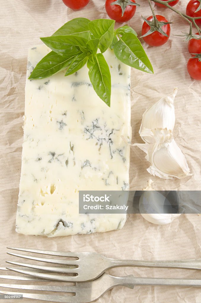 gorgonzola cheese on kitchen paper gorgonzola cheese with cherry tomato, garlic and basil on kitchen paper Appetizer Stock Photo