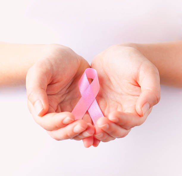 holding pink breast cancer awareness ribbon holding pink breast cancer awareness ribbon oncology photos stock pictures, royalty-free photos & images