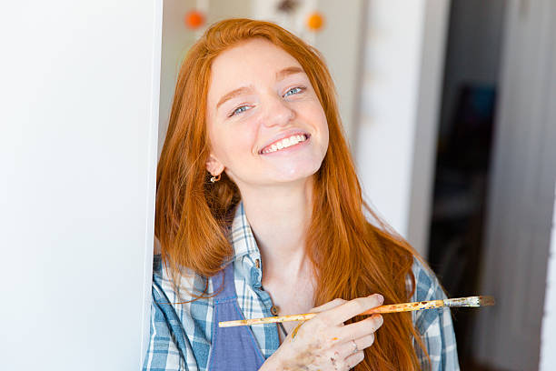istock Cheerful happy attractive young woman painter with brush 502129492