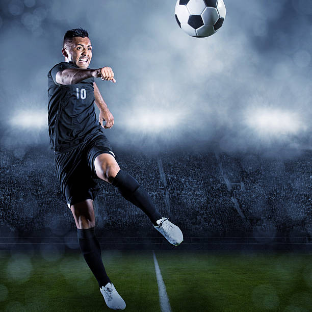 istock Soccer player kicking ball in a large stadium 502129801