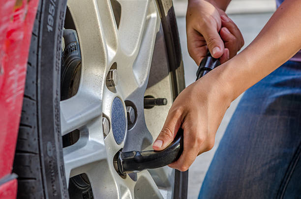 istock Woman is changing tire with wheel wrench 502130297