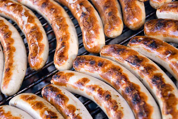 many barbecue german sausages on a roast