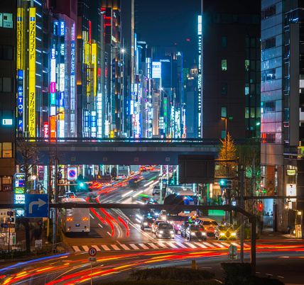 The colourful neon signs and bright lights of Ginza illuminating the traffic zooming through the dusk rush hour in the heart of downtown Tokyo, Japan's vibrant capital city. ProPhoto RGB profile for maximum color fidelity and gamut.