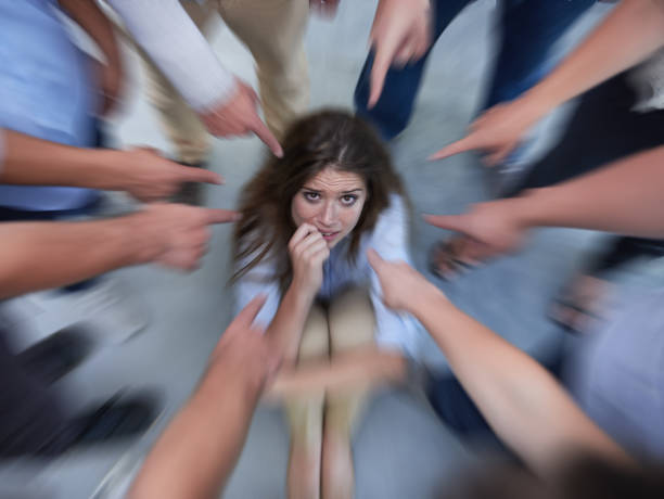 Crumpling under the pressure Shot of a fearful young woman trying to hide from her coworkers&#039; accusatory fingershttp://195.154.178.81/DATA/i_collage/pi/shoots/783578.jpg regret stock pictures, royalty-free photos & images