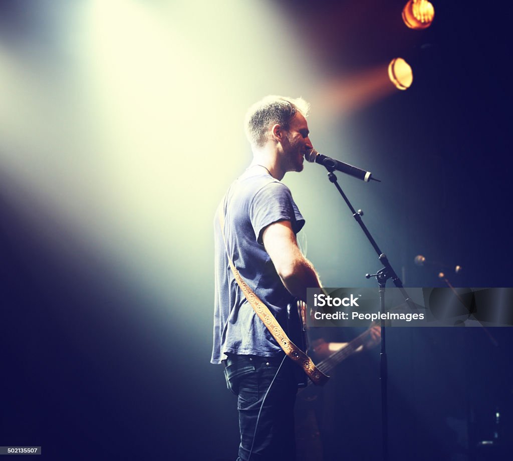 The music comes from his heart Shot of a solitary musician playing guitar and singing into a michttp://195.154.178.81/DATA/i_collage/pi/shoots/782423.jpg Live Event Stock Photo