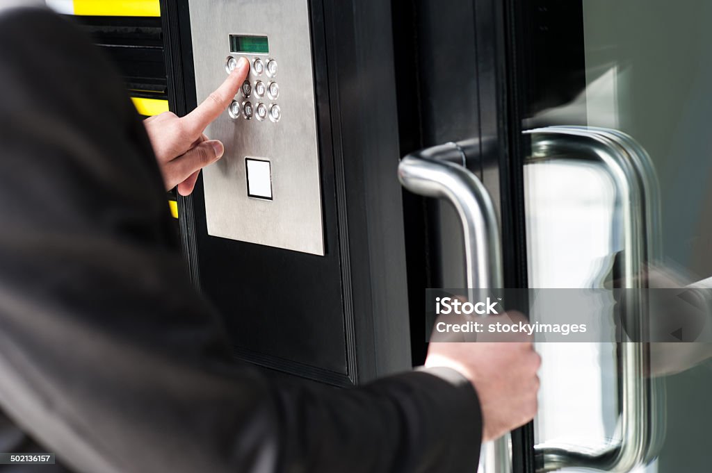 Man entering security code to unlock the door Businessman entering safe code to unlock the door. Accessibility Stock Photo