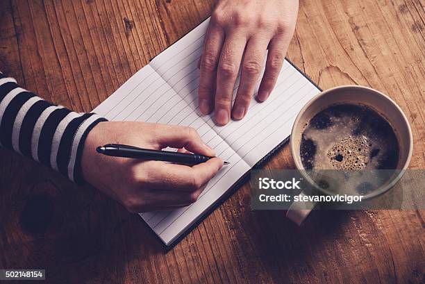 Woman Drinking Coffee And Writing A Diary Note Stock Photo - Download Image Now - Coffee - Drink, Writing - Activity, 2015