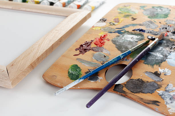 istock Art palette with paint and a brush on white background 502148422