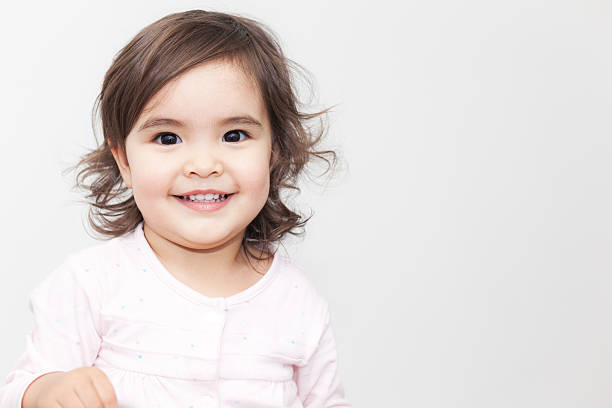 Smiling baby girl looking at camera on the white background