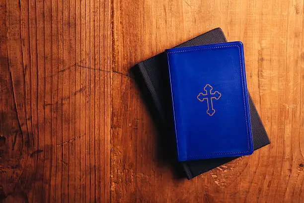 Holy Bible on old wooden church table, top view