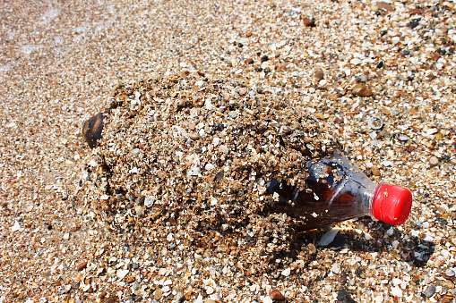 Pepsi Cola bottle on the sand by the sea. Azov