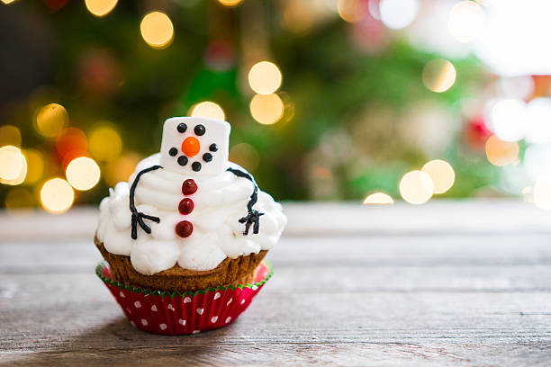 istock Snowman cupcake on wooden background 502155298
