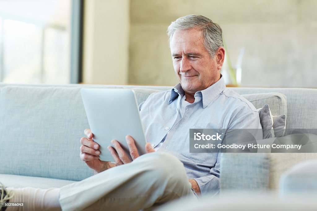 Keeping himself up to date Shot of a retired man using a digital tablet in his home Active Lifestyle Stock Photo