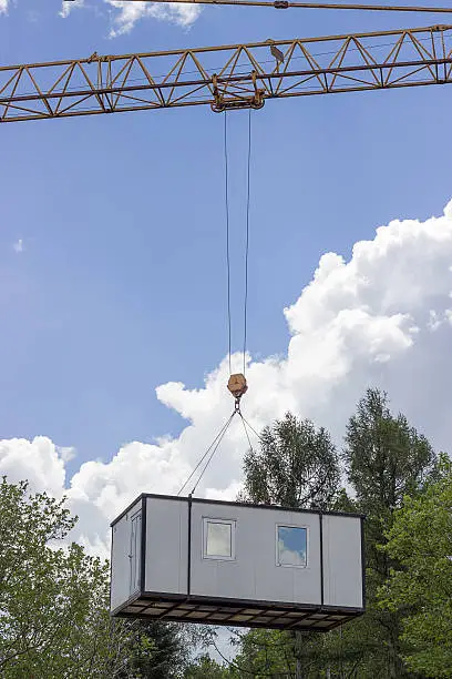 Photo of crane lifting and moving container house