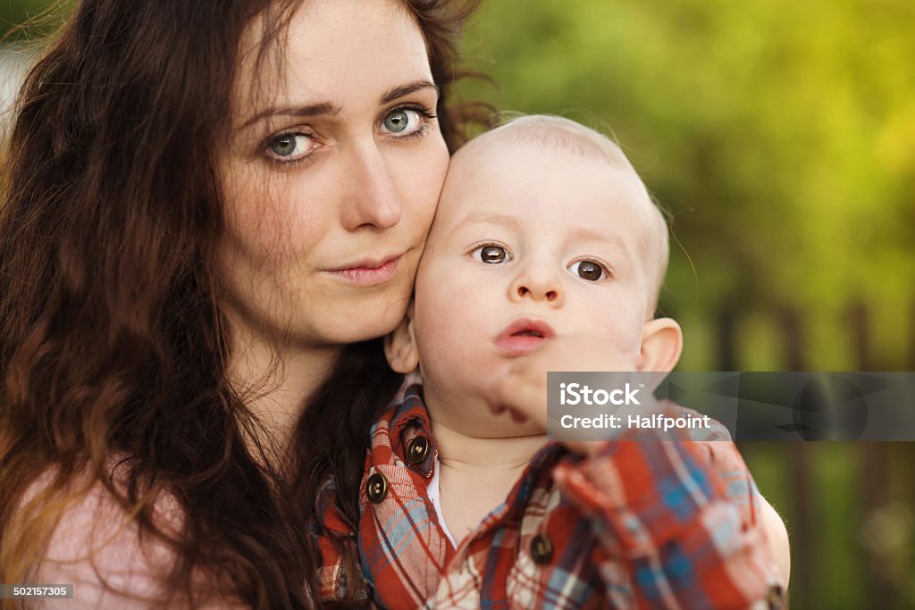 Mother holding her son Portrait of a crying little boy who is being held by her mother, outdoors Sadness Stock Photo