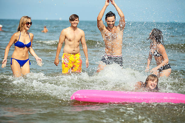 Young happy young friends playing in the Baltic sea. Swinoujscie, Poland.