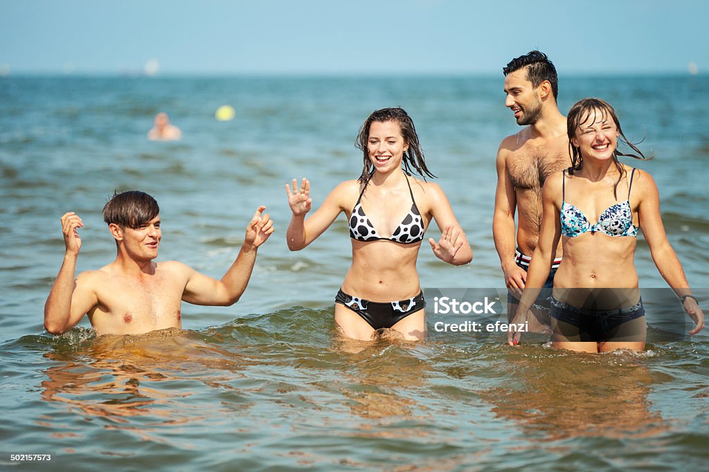 Felizes amigos brincando na água - Foto de stock de 20 Anos royalty-free