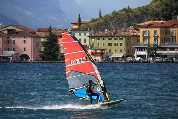Torbole, Italy - July 10, 2014: A windsurfer pro-rider on Lake Garda against the Torbole panorama backdrop. 