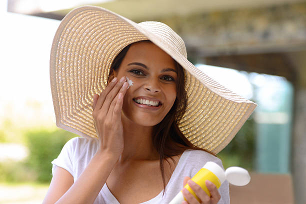 Better safe than sorry! An attractive young woman applying sunscreen to her facehttp://195.154.178.81/DATA/i_collage/pi/shoots/783592.jpg sun hat stock pictures, royalty-free photos & images