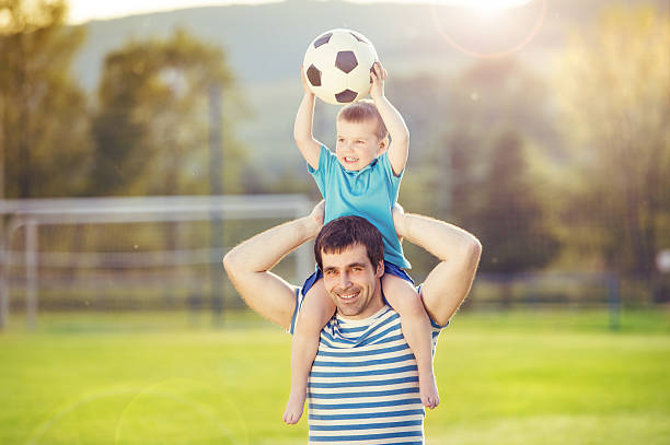 istock Father and son playing football 502158561