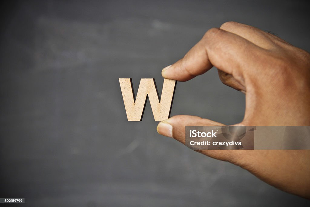 Hand holding alphabet Human hand holding wooden letter blocks Letter W Stock Photo