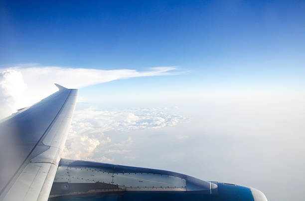 istock wing of plane with blue sky and white clouds . 502160967