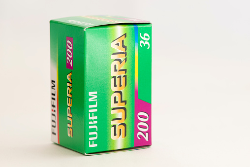 Antibes, France - December 21, 2015: Studio shot of Fujifilm Superia 200 colour negative film retail box, with a film SLR camera behind. The film is manufactured by Fujifilm Holdings Corporation, headquartered in Tokyo, Japan.