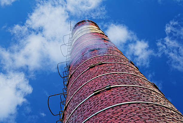 Industrial brick chimney against blue sky