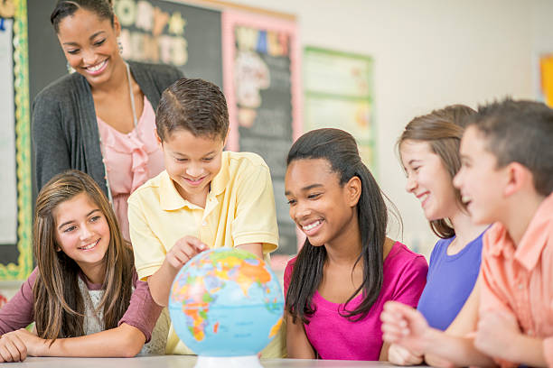 mirando en el mundo en geografía clase - adolescence teenager globe map fotografías e imágenes de stock